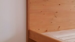A wooden bed frame with a slatted headboard and footboard, positioned against a plain wall. - Apartment 5 – Well-Equipped Kitchen, Spacious Outdoor Area, and Beautiful Nature Views (Kirchseeon)