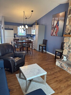 A living room with a leather sofa, a marble coffee table, and a stone fireplace. - NEWLY LISTED! The Perfect View of the Lake! (Osage Beach)