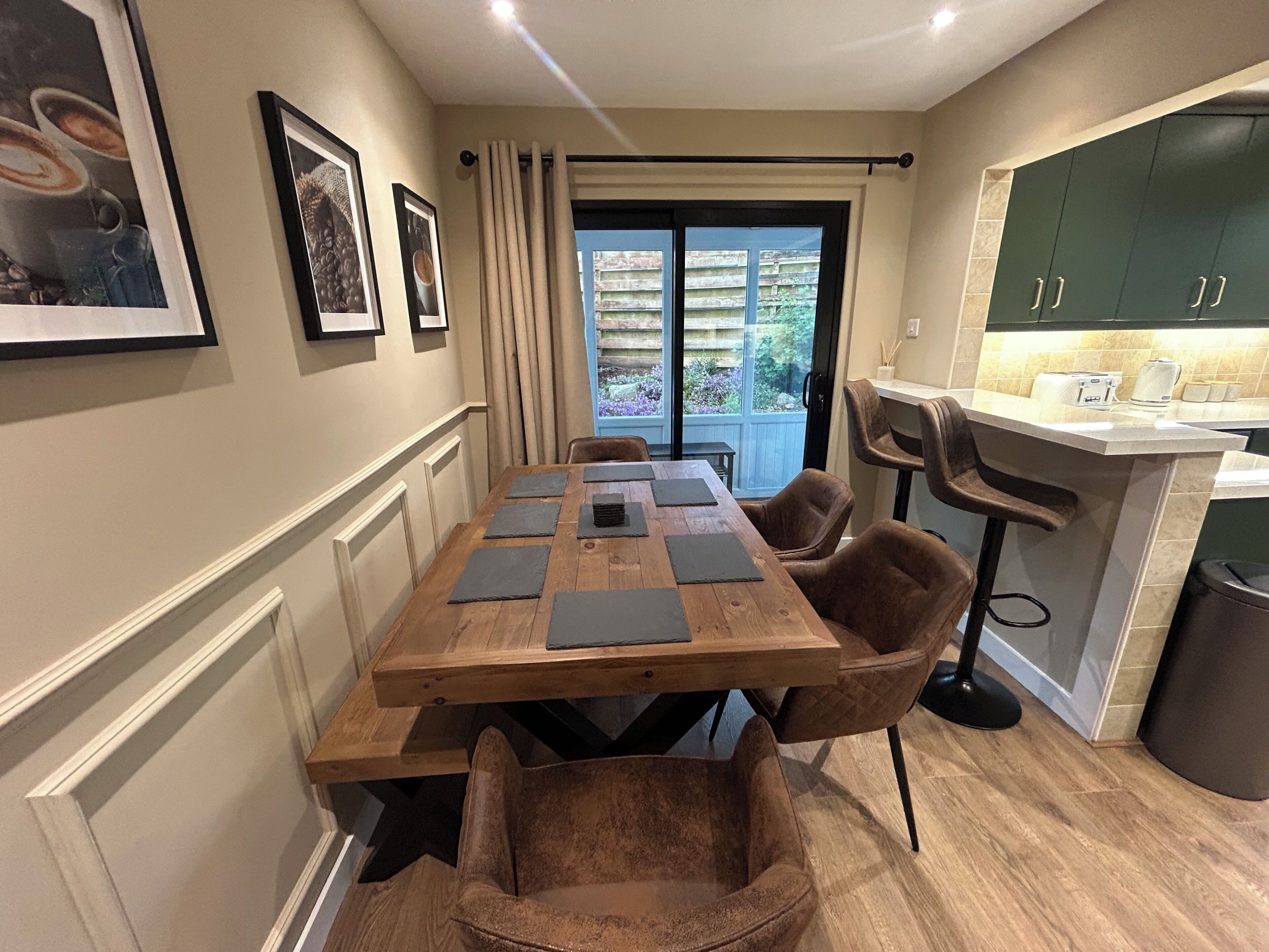 A dining area with a wooden table, chairs, and a view of the outside.