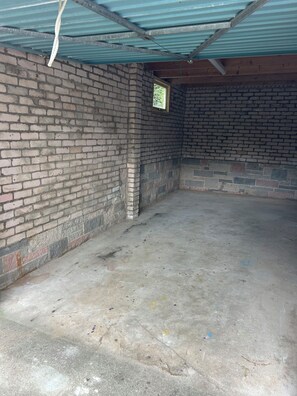 A room with brick walls, a concrete floor, and a metal roof. - Newly renovated cosy coastal retreat within walking distance of village pub! (Kippford)