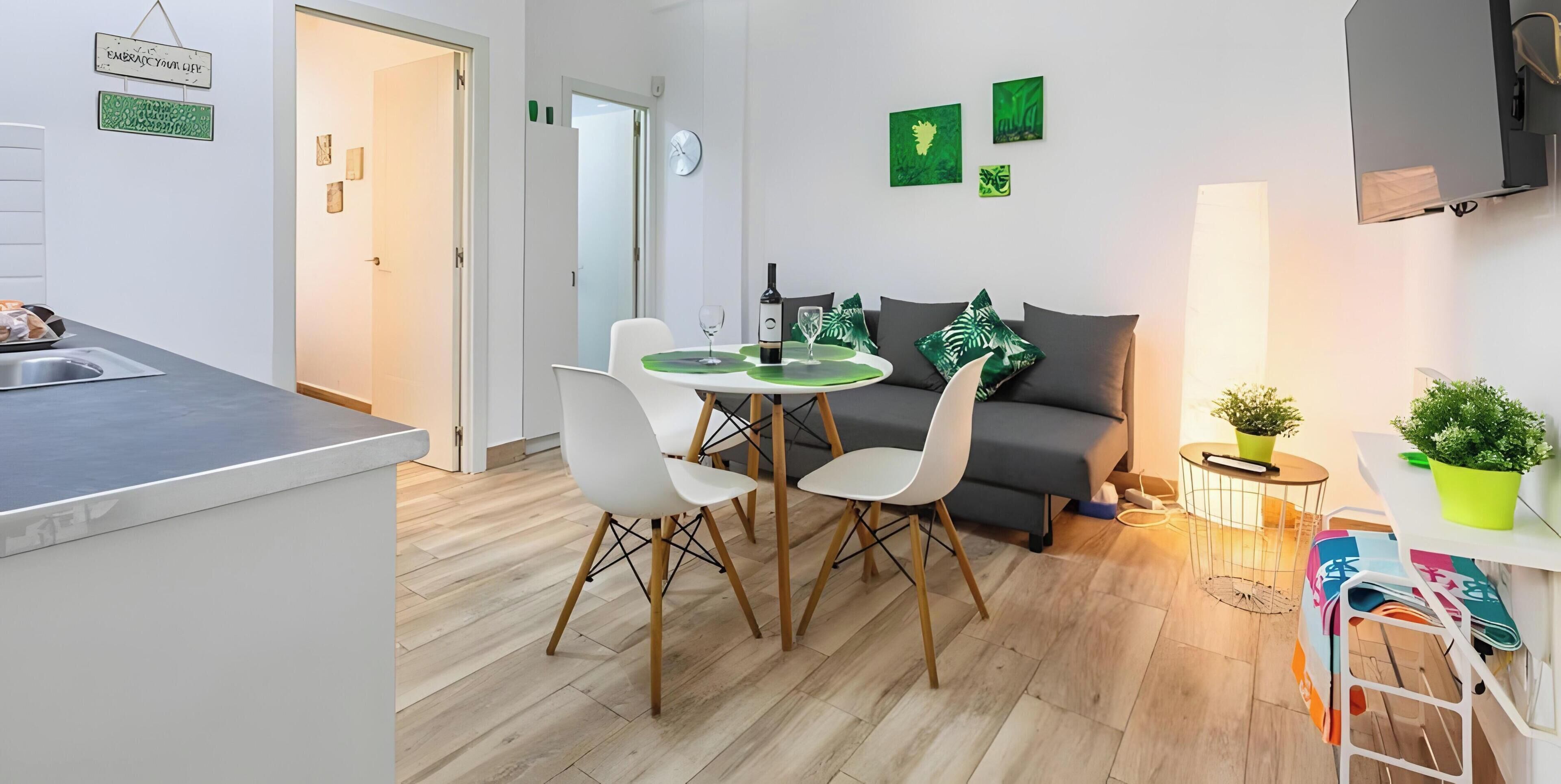 Ein modernes Wohnzimmer mit Essbereich, einer Couch und einem Fernseher.