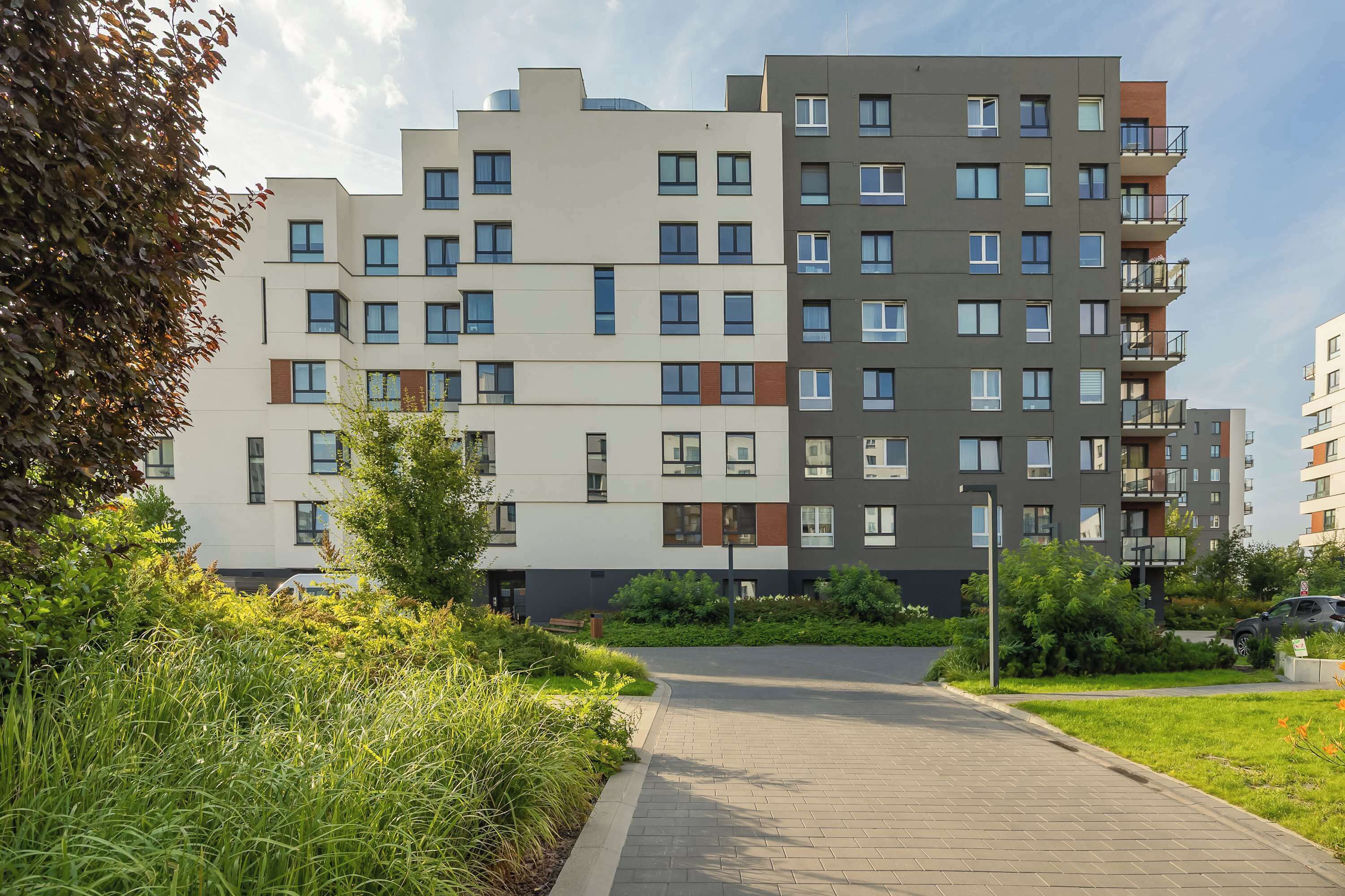 Un immeuble résidentiel à plusieurs étages, doté d’une architecture moderne, et dont la façade présente un mélange de balcons et de fenêtres.
