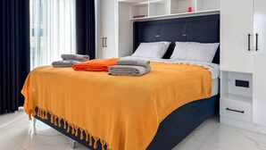 A modern bedroom with a bed, white wardrobe, and a window with curtains. - Qoople Elite 2 City B1 - Cozy 1-bedroom apartment in Alanya (Alanya)