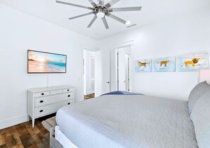 A bedroom with a bed, a ceiling fan, a TV, a dresser, and wall art. - Atlantis: Largest Pool, Spa, Game Room, Fire Pit, 2 Min to Beach, Beach Gear (Miramar Beach)