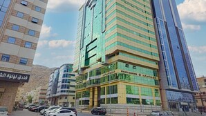 A multi-story hotel with a modern design, featuring a prominent glass facade and a central entrance. - Romance AlBadr Hotel (Makkah)