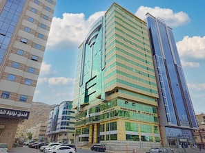 A multi-story hotel with a modern design, featuring a prominent glass facade and a central entrance. - Romance AlBadr Hotel (Makkah)