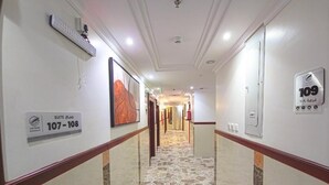 A hotel corridor with a patterned floor, a sign indicating room numbers 107-108, and a door with a number 109 sign. - Romance AlBadr Hotel (Makkah)