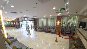A hotel lobby with a reception desk, seating area, and a red rope barrier. - Romance AlBadr Hotel (Makkah)