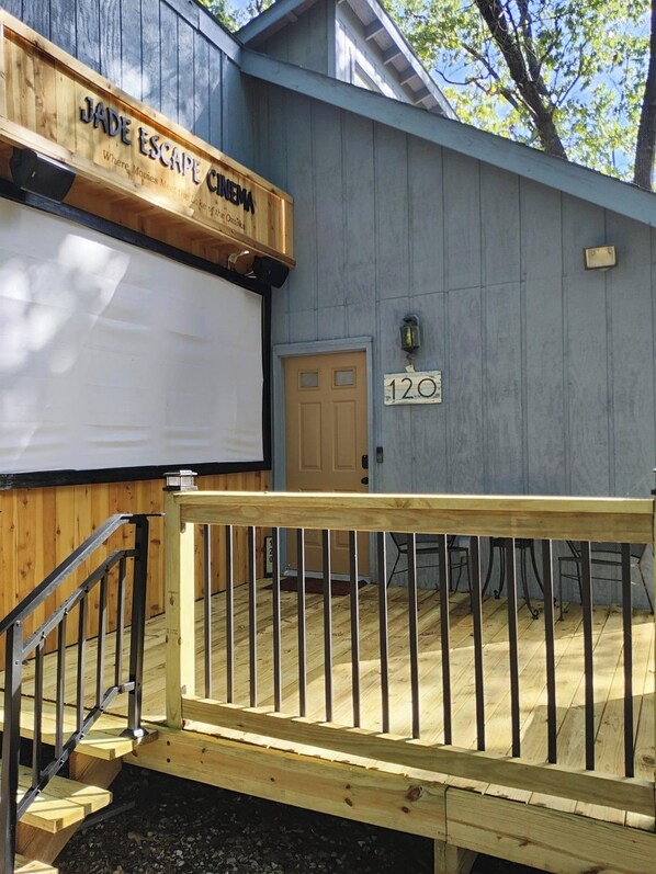 A wooden building with a sign reading 'JADE ESCAPE CINEMA' and a door labeled '120'.