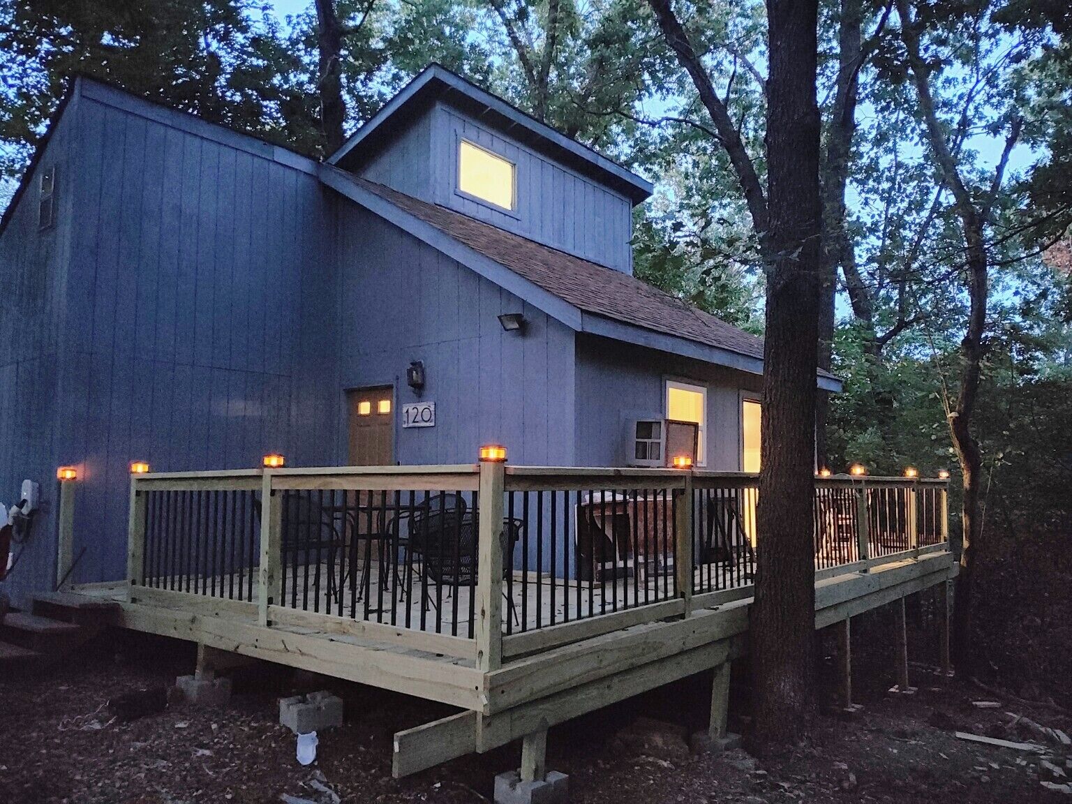 A two-story building with a wooden deck and a metal railing.