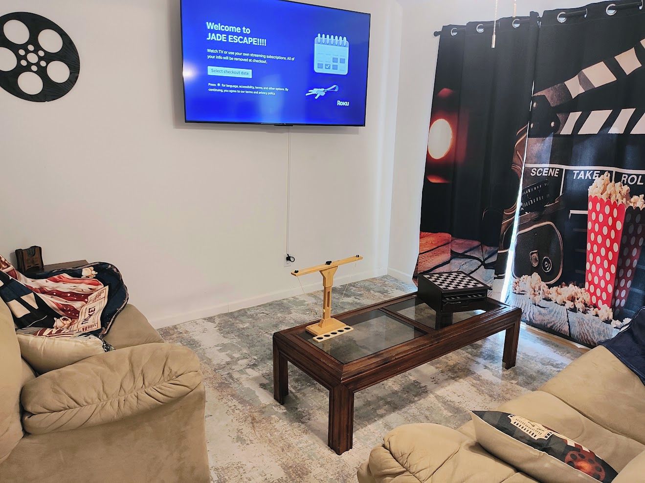 Un salon avec un téléviseur à écran plat fixé au mur, une table basse et deux canapés.