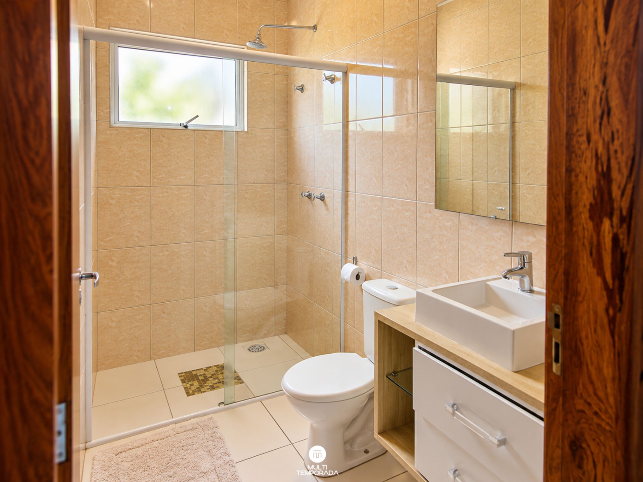 Une salle de bain avec une douche à parois de verre, des toilettes, un lavabo et un miroir.
