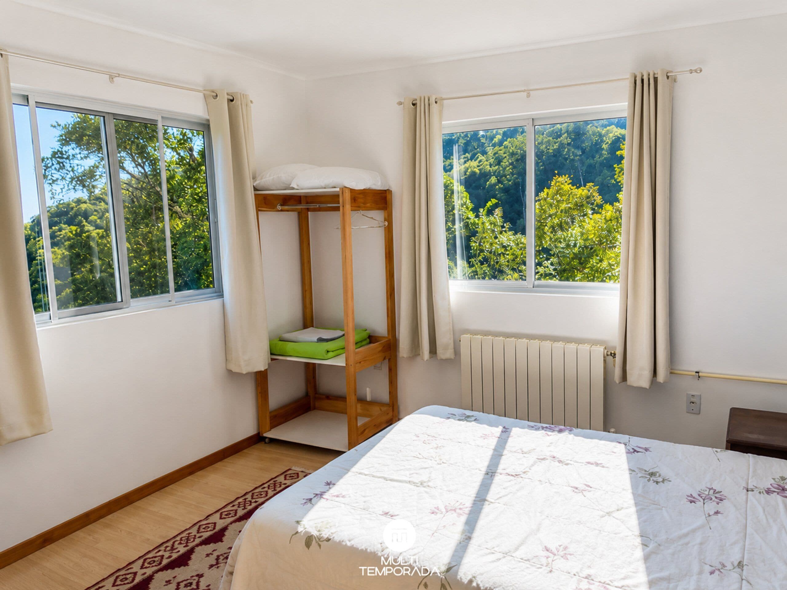 Una habitación con literas, un radiador y una ventana con cortinas.