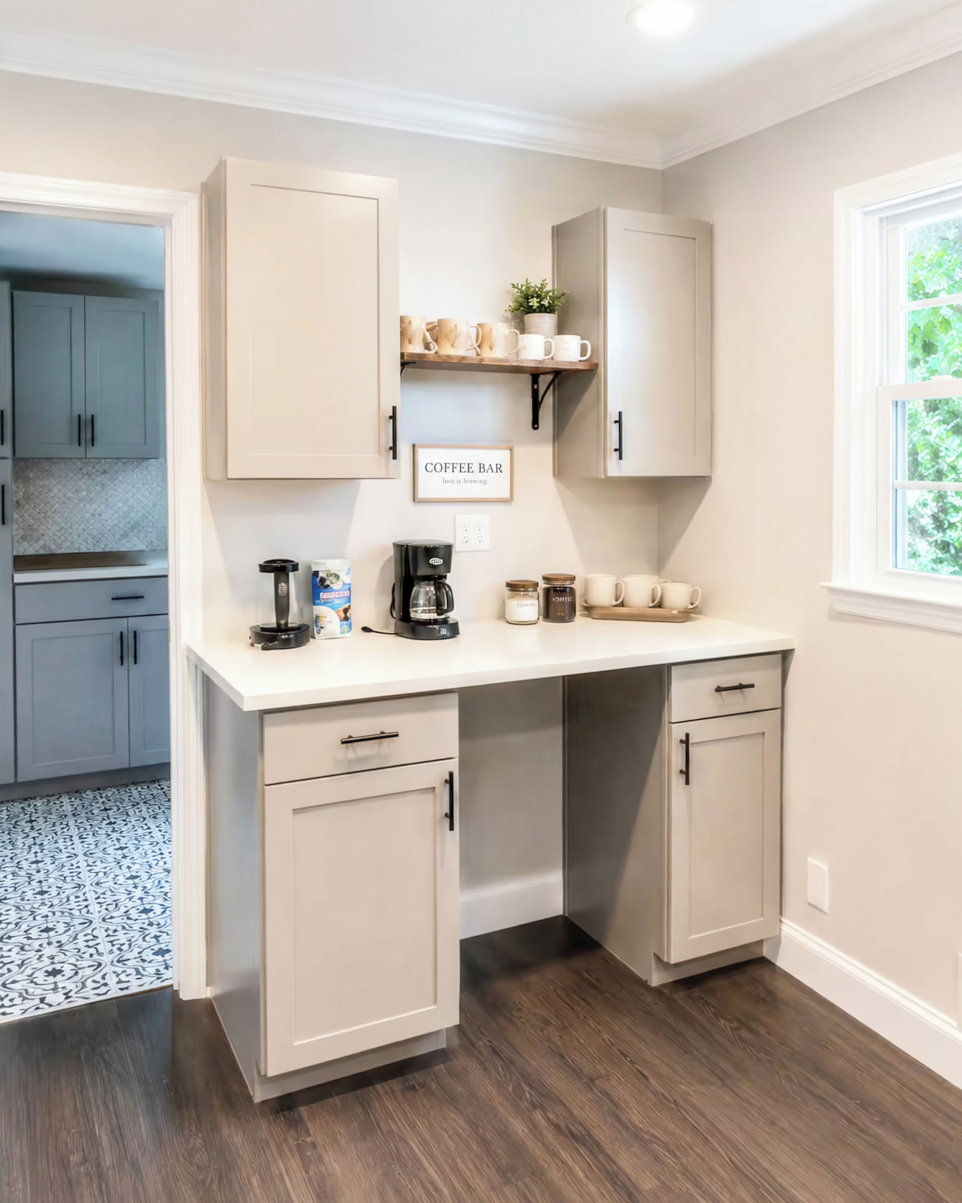 A kitchen with a built-in coffee bar, cabinets, and a window.