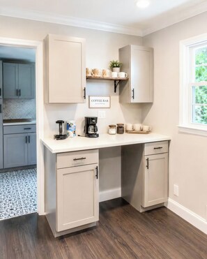 A kitchen with a built-in coffee bar, cabinets, and a window. - Tucked away in Tucker (Tucker)