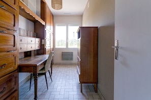 A kitchen with wooden cabinets, a dining table, and a window with a view.