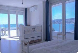 A bedroom with a bed, a dresser, a chair, and a view of the sea. -     Beautiful Apartment Near the Beach with Spectacular Sunset ViewsShëngjin (Shëngjin)