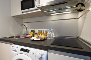 A modern kitchen with a microwave, a built-in oven, a sink, and a dishwasher. - Apartment 'La Rosaleda' with Balcony, Wi-Fi and Air Conditioning (Málaga)