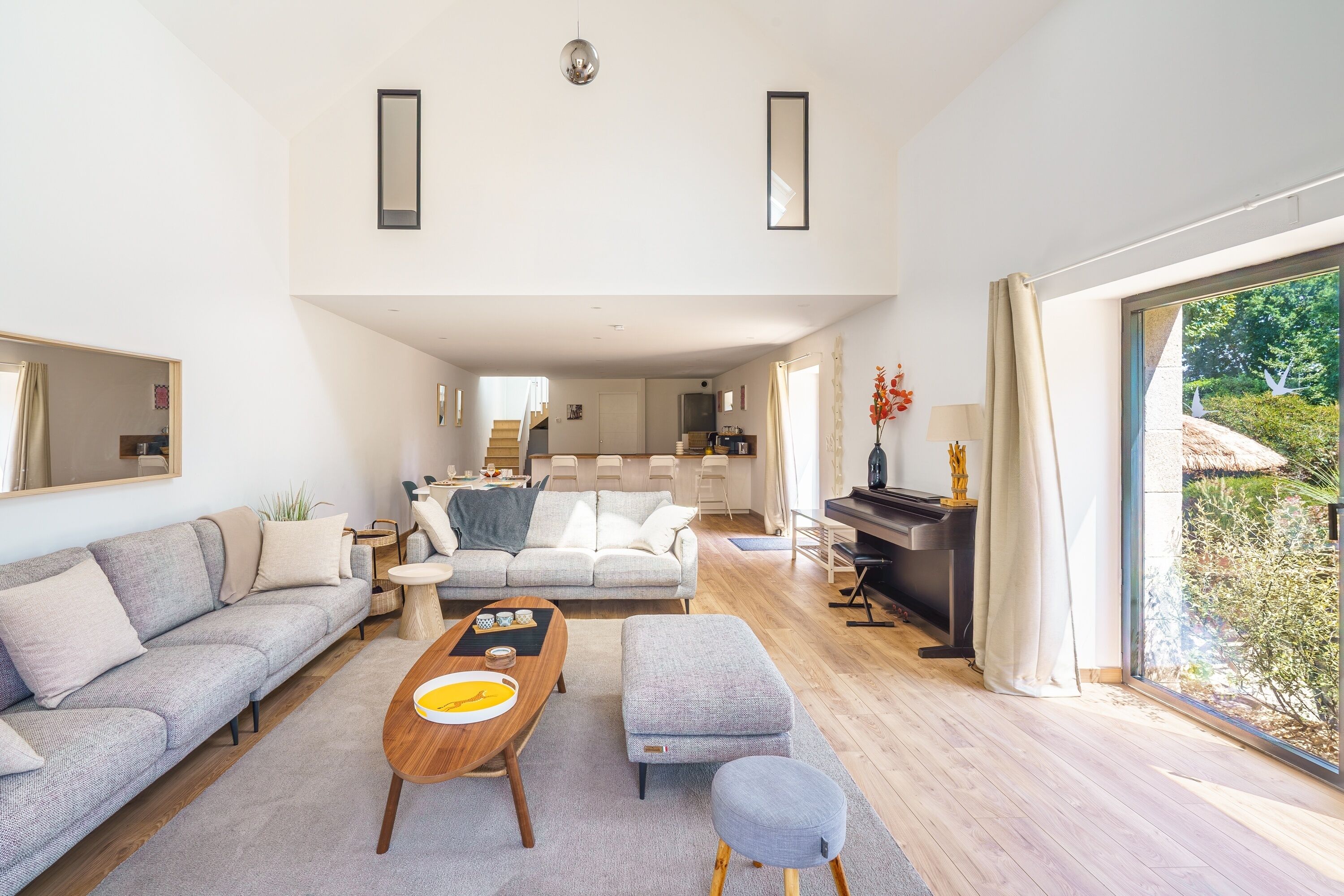 A spacious living area with a sofa, a coffee table, and a piano.
