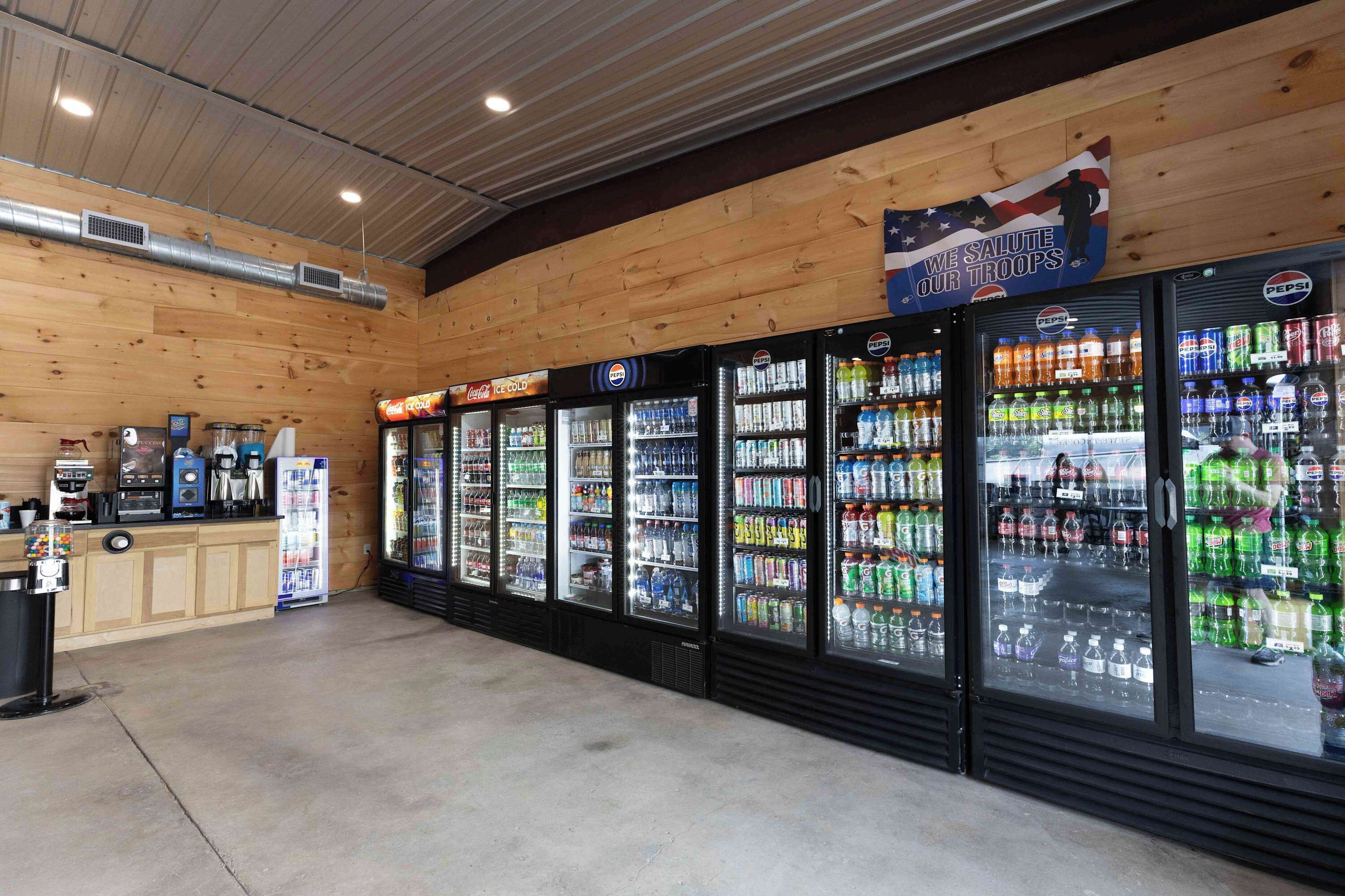 A vending area with Pepsi and Coca-Cola coolers, a coffee machine, and a gumball machine.