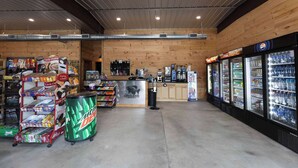 Una tienda de conveniencia con una variedad de bocadillos, un refrigerador de refrescos y una máquina de café.