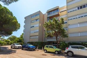 Ein mehrstöckiges Wohnhaus mit Parkplatz davor.
