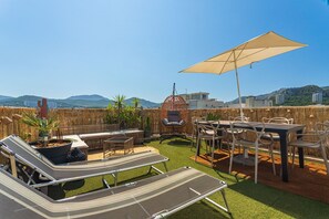 A rooftop terrace with outdoor seating, a grill, and a view of the cityscape. - Lou Cigaloun - Rooftop panoramique près des plages (Marseille)