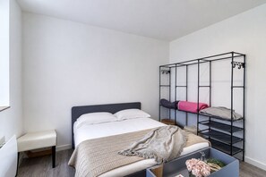 A bedroom with a bed, a bench, a bunk bed, and a storage unit. - Le Central - Appt pour 2 en plein cœur de Calais (Calais)