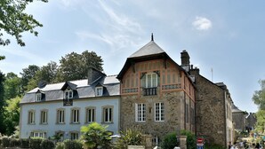 Ein traditionelles Steinhaus mit Satteldach und einem Balkon.