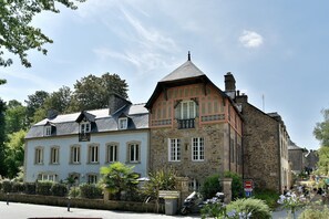 Ein traditionelles Steinhaus mit Satteldach und einem Balkon.