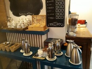 Una estación de café con diverso equipo para prepararlo y un panel con la carta.