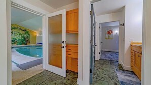 Ein Zimmer mit Pool, Holzschränken und Fliesenboden.