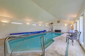 An indoor swimming pool with a clear view of the pool area, a clock on the wall, and a seating area with chairs. - The Pool House - Private Pool & Relaxing Outdoor Retreat (Ferndale)