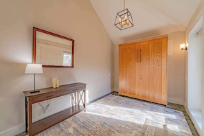 A hallway with a wooden console table, a mirror, a geometric light fixture, and a wooden wardrobe. - The Pool House - Private Pool & Relaxing Outdoor Retreat (Ferndale)
