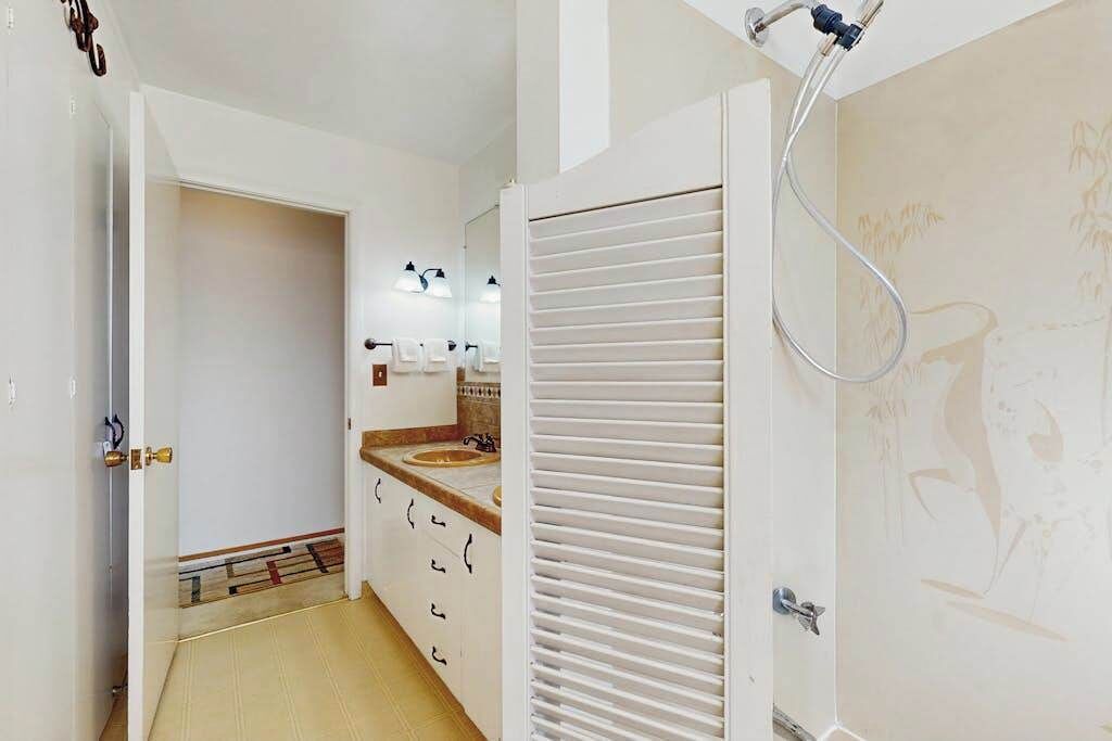 Een badkamer met een douche, toilet en wastafel.