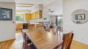 Eine moderne Küche mit Holzausstattung, einem Esstisch und einem Deckenventilator.