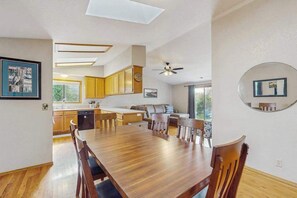 Eine moderne Küche mit Holzausstattung, einem Esstisch und einem Deckenventilator.