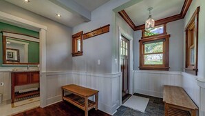 A room with wooden flooring, a wooden bench, a mirror, and a window with a view. - The Trinidad Pearl - Oceanfront Home & Hot Tub (Trinidad)