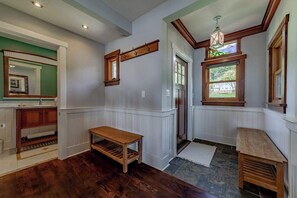 A room with wooden flooring, a wooden bench, a mirror, and a window with a view. - The Trinidad Pearl - Oceanfront Home & Hot Tub (Trinidad)