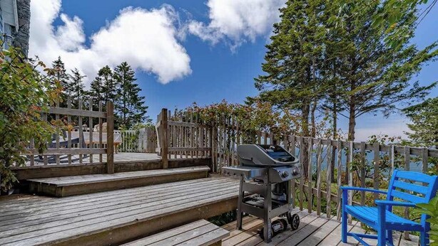 A wooden deck with a barbecue grill and a blue bench. - The Trinidad Pearl - Oceanfront Home & Hot Tub (Trinidad)