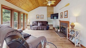 Amplia sala de estar con techo de madera, chimenea y sofá.