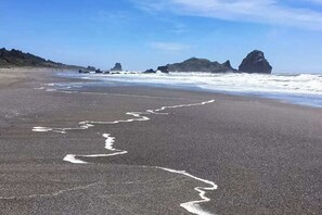 A beach with a clear path leading to the water, surrounded by rocky formations. - Ocean Treasures: Retro Home, 4 Min Walk to Beach (Smith River)