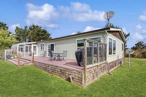 A mobile home with a covered patio, satellite dish, and a grill. - Pacific View Escape - Bay Views & Jetted Tub (Loleta)