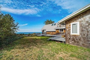 A modern house with a deck, a view of the ocean, and a clear sky. - Seagull's Bluff - Scenic Coastal Retreat with Ocean Views (Trinidad)