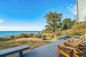 A wooden deck with a bench and chairs overlooking a coastal landscape. - Seagull's Bluff - Scenic Coastal Retreat with Ocean Views (Trinidad)