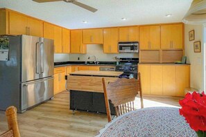 A modern kitchen with wooden cabinets, stainless steel appliances, and a central island.