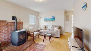 Ein Wohnzimmer mit Kamin, Sofa und Fernseher.