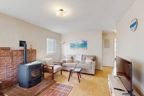 Ein Wohnzimmer mit Kamin, Sofa und Fernseher.