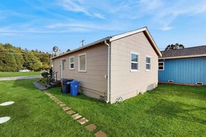 Ein eingeschossiges Haus mit geneigtem Dach, einer Veranda und einer kleinen angebauten Garage.