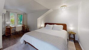 Un dormitorio con una cama grande, un escritorio y una ventana.